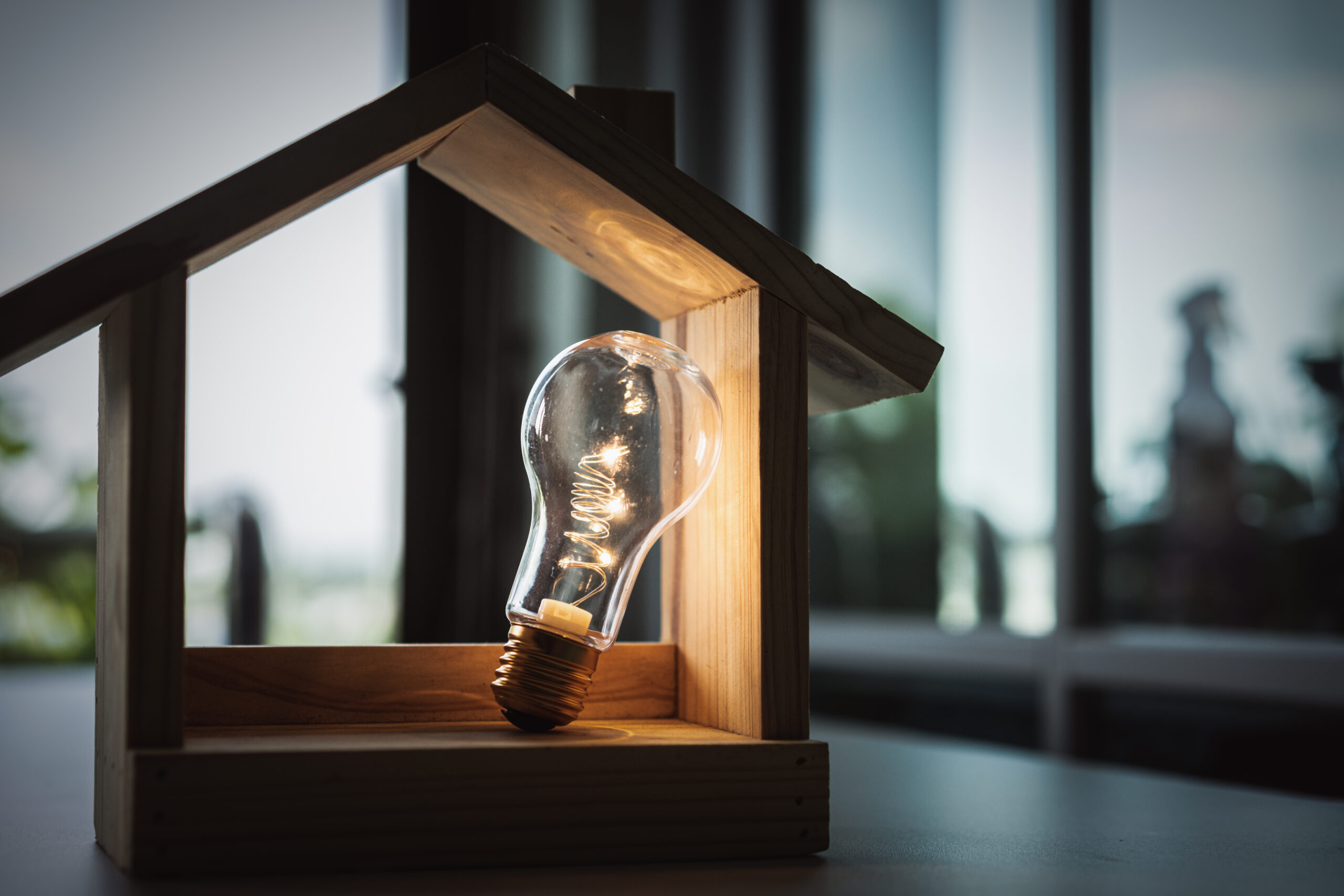 Light,Bulb,With,Wood,House,On,The,Table,,A,Symbol